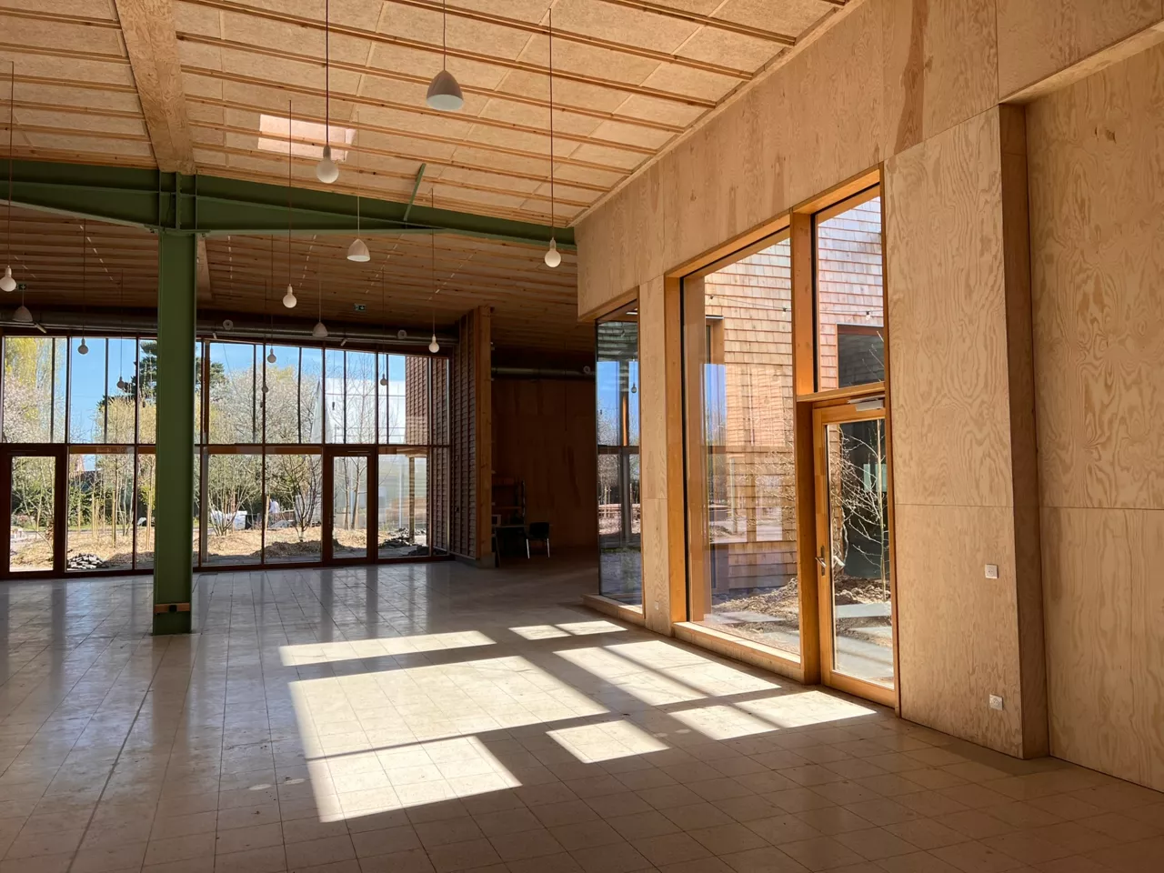 Intérieur du bâtiment démonstrateur de Noeux environnement, construit en matériaux biosourcés avec une ossature bois et de larges baies vitrées pour offrir lumière naturelle et confort durable.